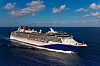 Et stort cruiseskip seiler på rolig sjø under en blå himmel med spredte skyer.